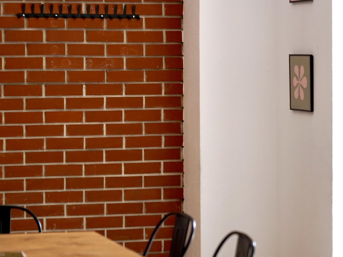 Sala z ceglanym łukiem i stolikami